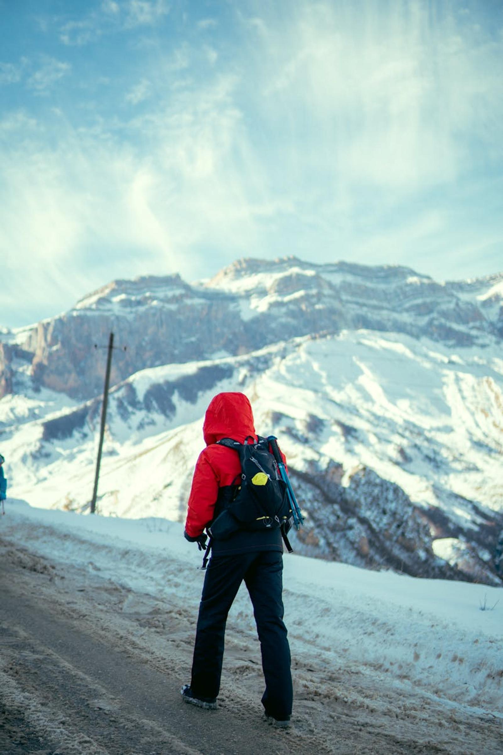 Person in red jacket hiking in the snowy mountains of Qusar, Azerbaijan, near Mount Shahdag