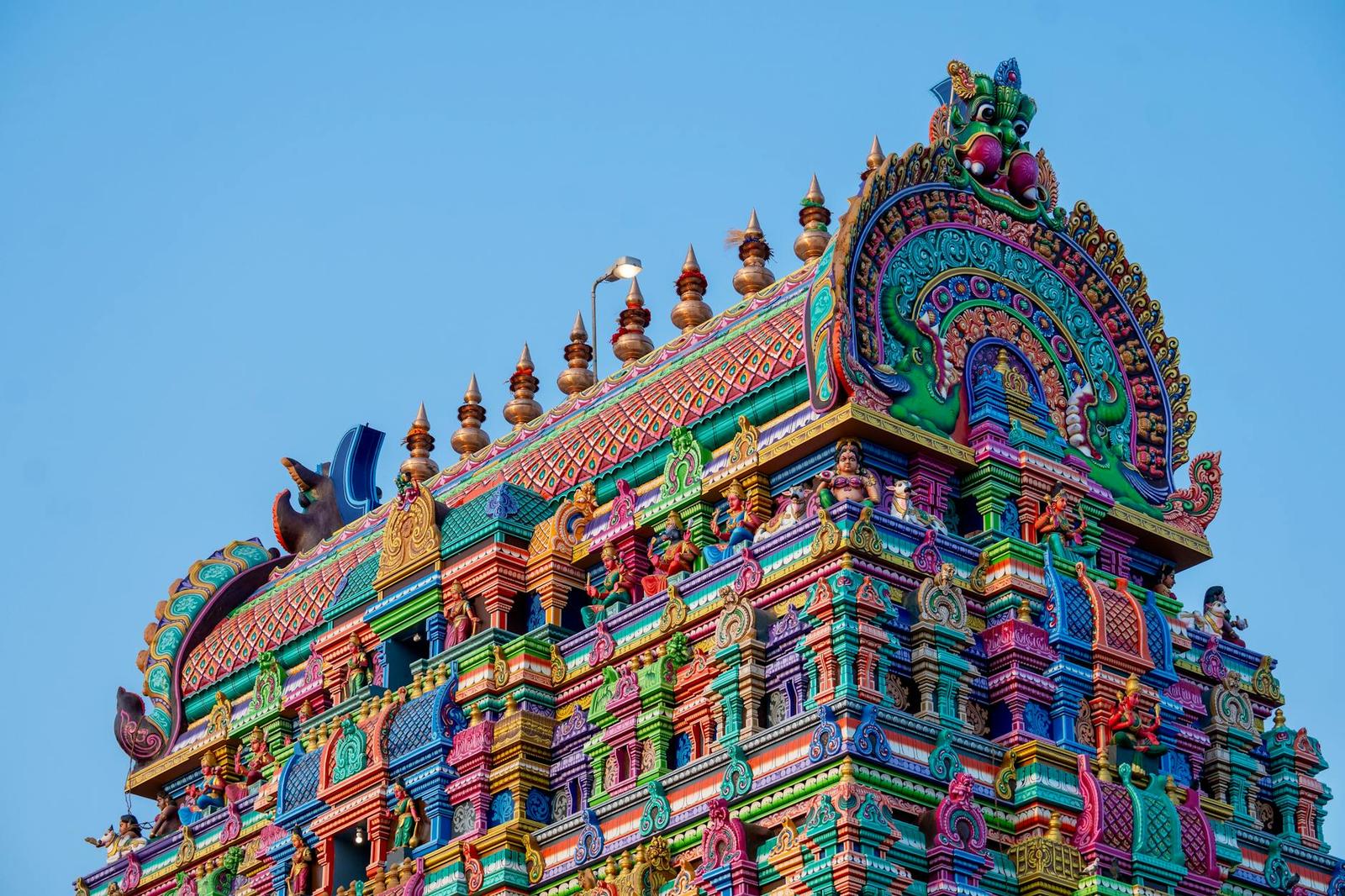 Close-up of a brightly painted temple tower covered in carved figures