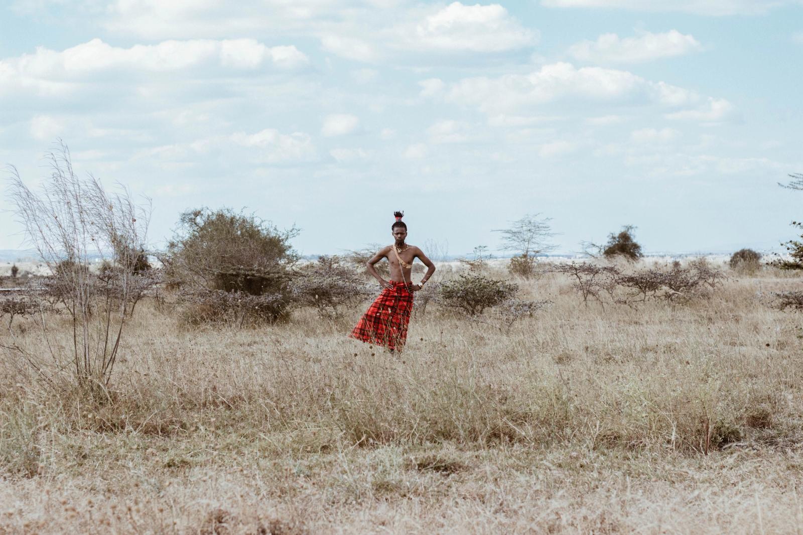 Person in traditional clothing standing in a savannah landscape in Kenya