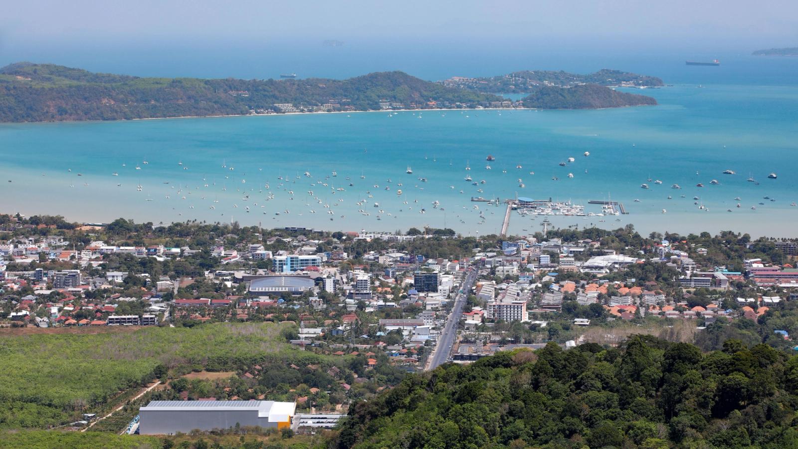 A stunning aerial view of Karon Beach, Phuket, featuring turquoise waters and urban landscape