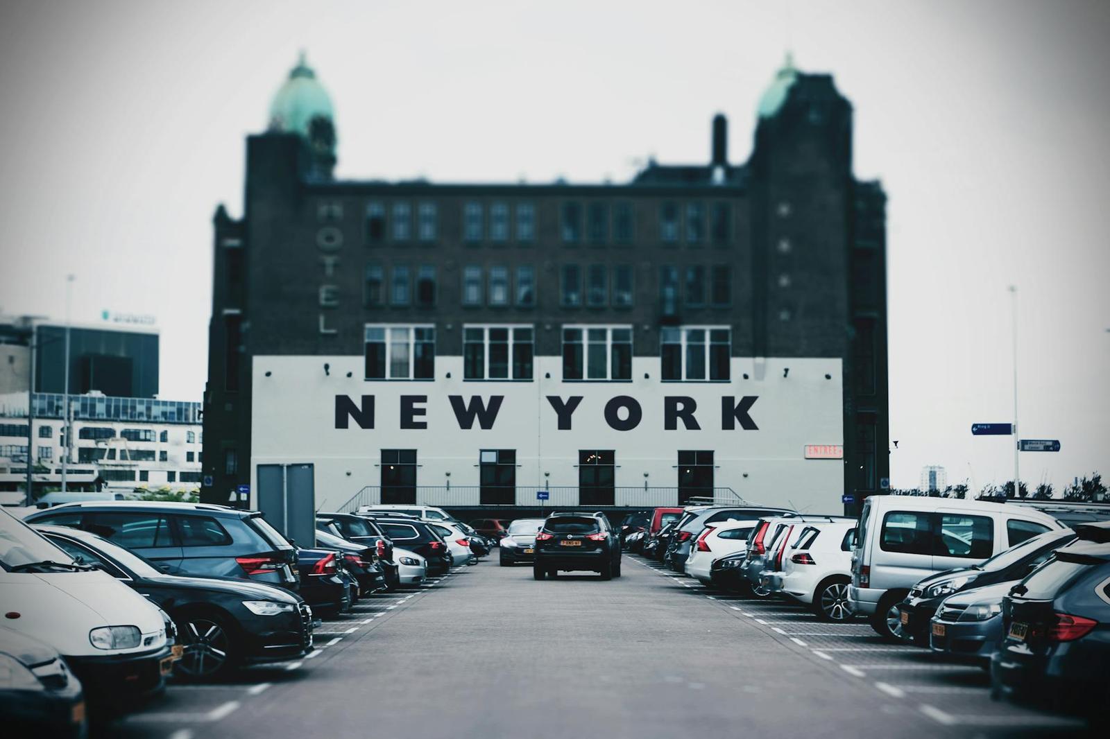 A domed brick hotel building seen across a full parking lot