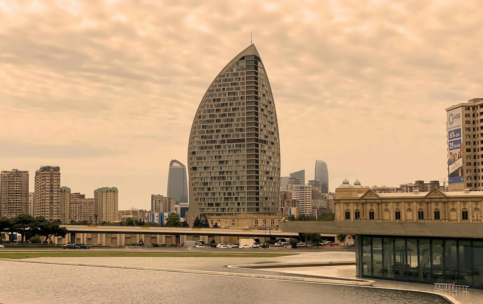Cityscape of Baku with modern architecture against a cloudy sky