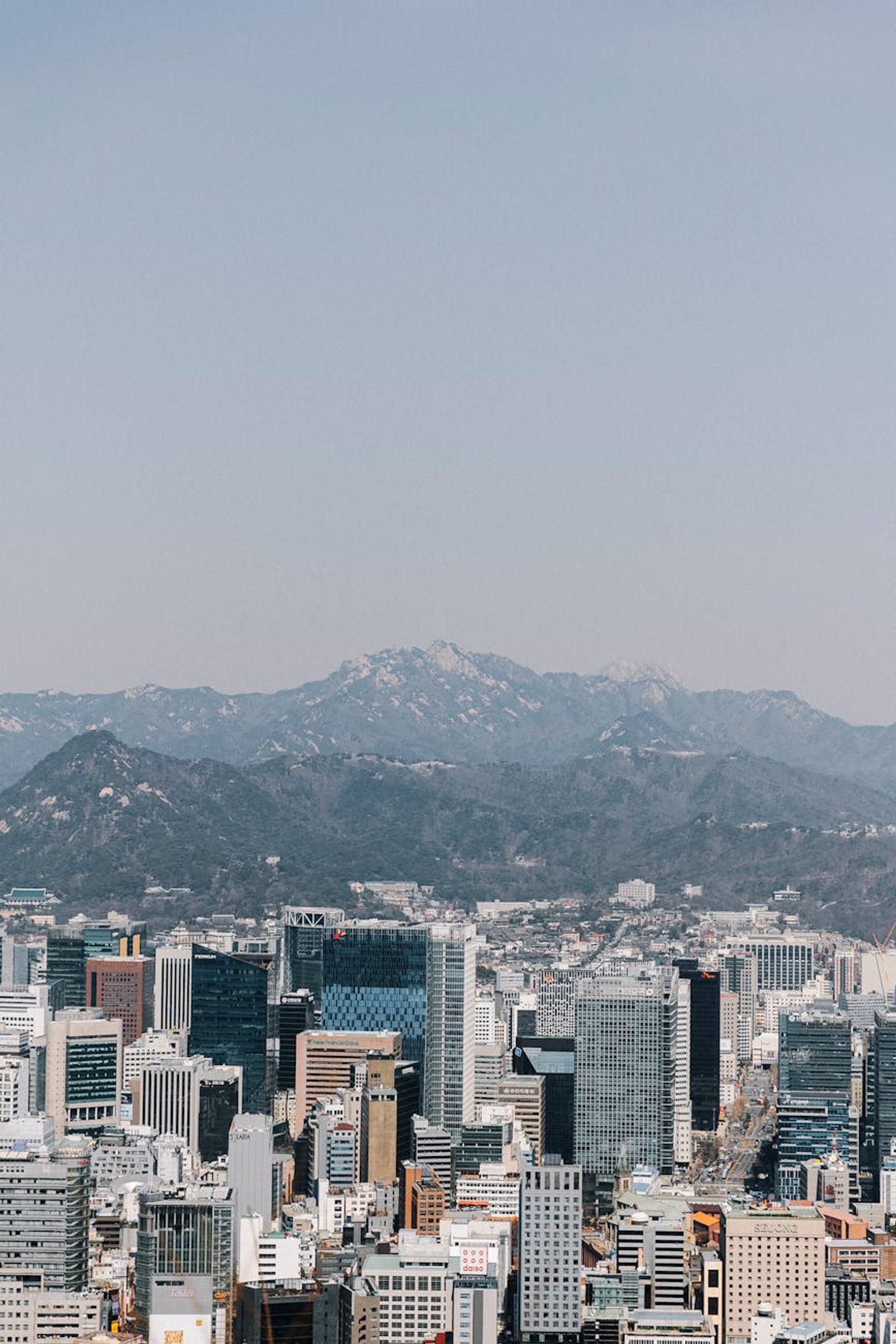 Dense high-rise skyline backed by hazy mountain ridges