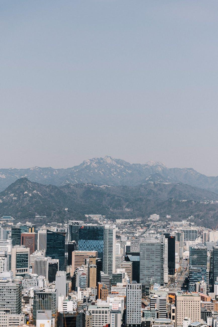 Dense high-rise skyline backed by hazy mountain ridges