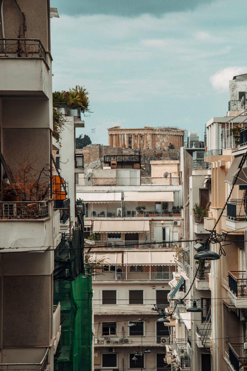 An urban street view showcasing the Parthenon amidst Athens' modern architecture