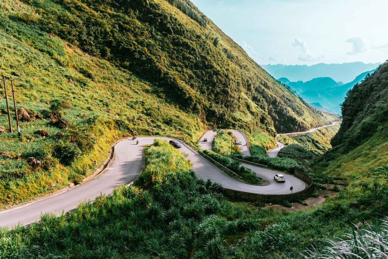 Hairpin mountain road winding through terraced green slopes