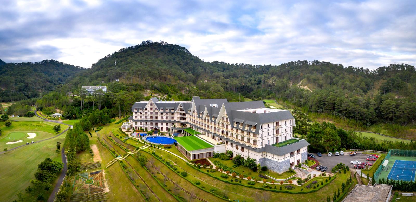 Scenic aerial photo of a luxury hotel surrounded by lush mountains