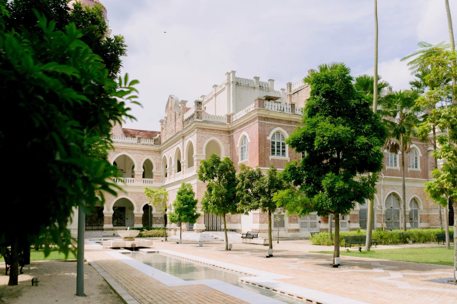 A lush garden view of historical colonial architecture in Kuala Lumpur, Malaysia