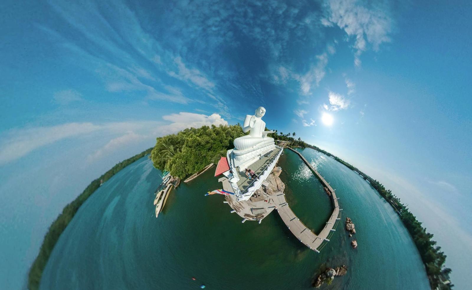 A stunning 360-degree aerial view of a Buddha statue by a tranquil lake in Sri Lanka