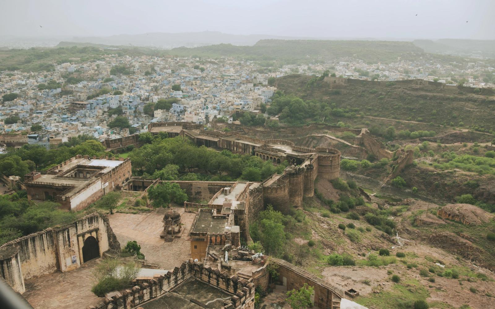 Aerial view of the historic Mehrangarh Fort overlooking Jodhpur city, framed by lush greenery