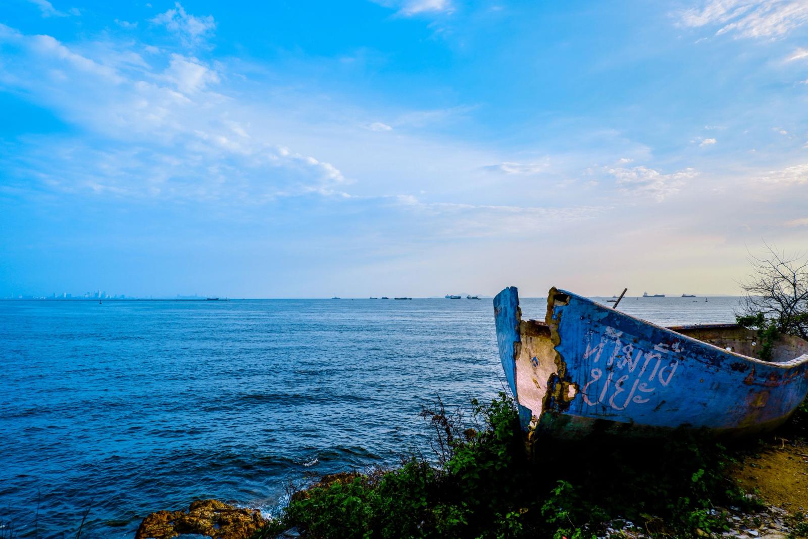 Serene seascape of a vintage boat by the Pattaya seashore under a vibrant sky