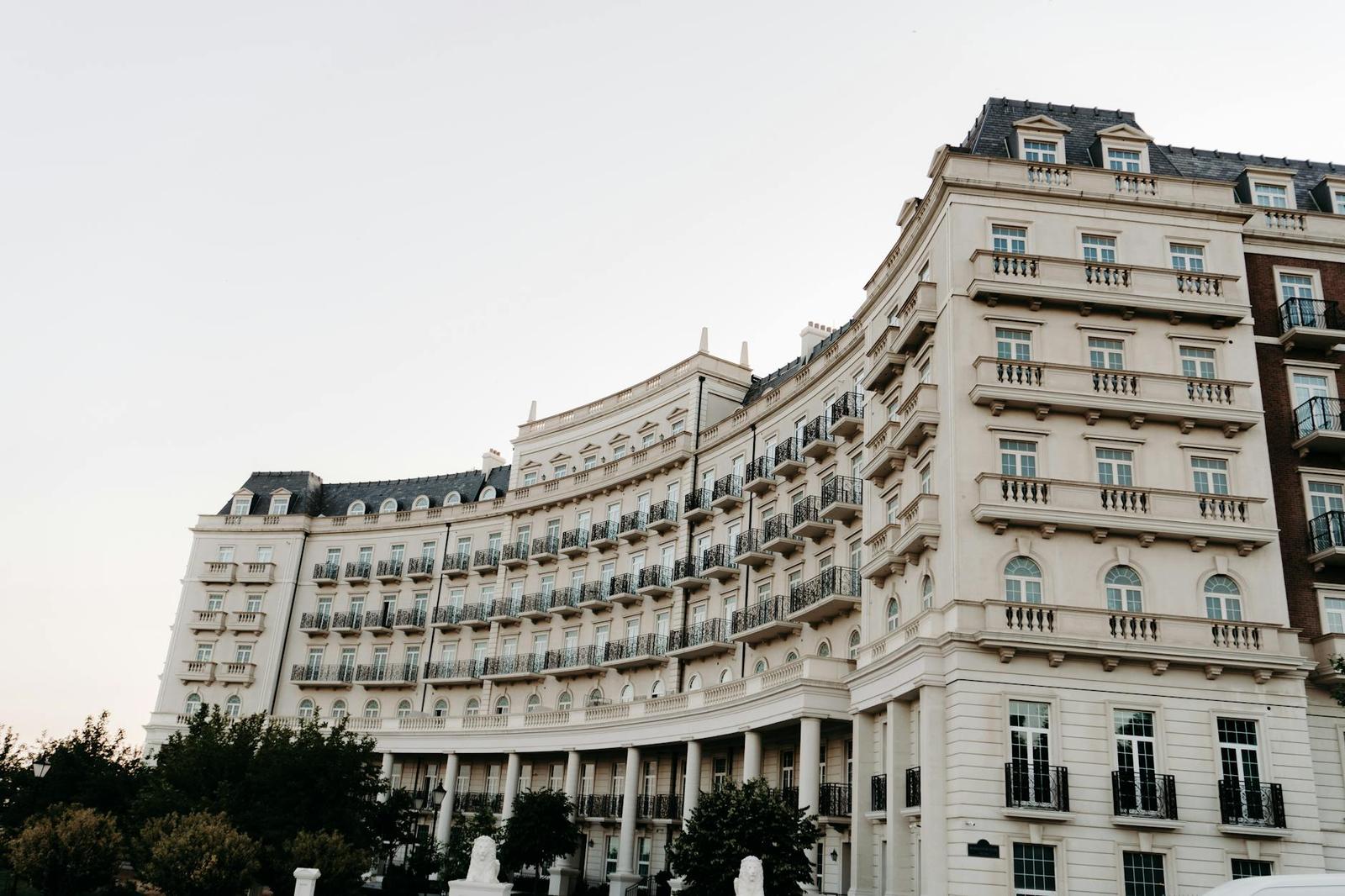 An ornate cream-coloured curved hotel facade with rows of balconies