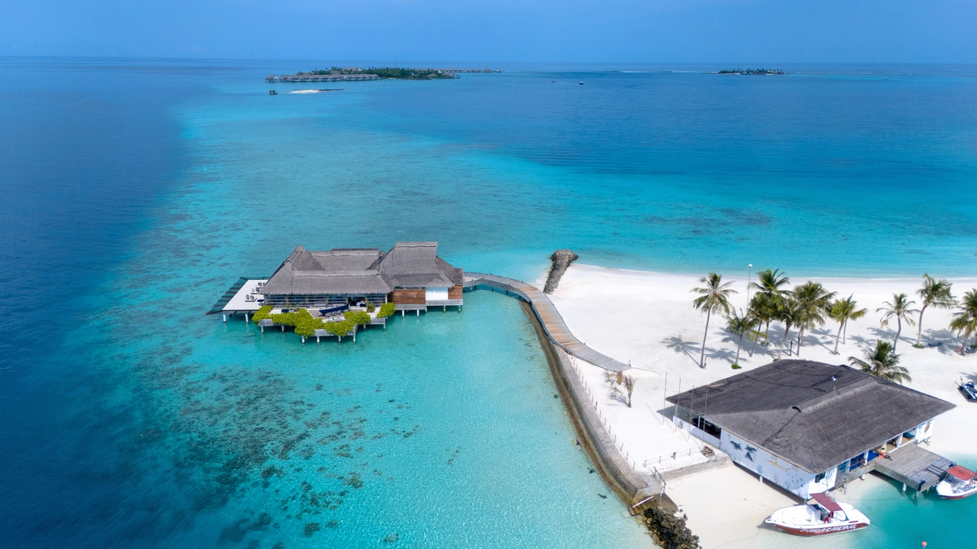 Stunning aerial photo of a tropical beach resort in Maldives surrounded by turquoise waters and white sandy beaches