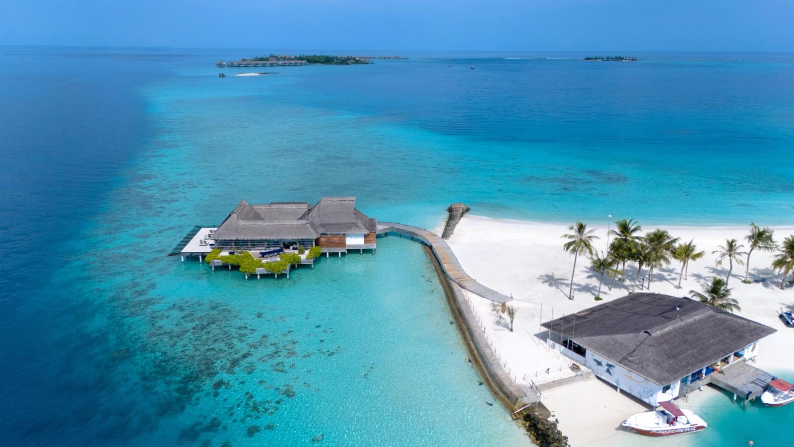 Stunning aerial photo of a tropical beach resort in Maldives surrounded by turquoise waters and white sandy beaches