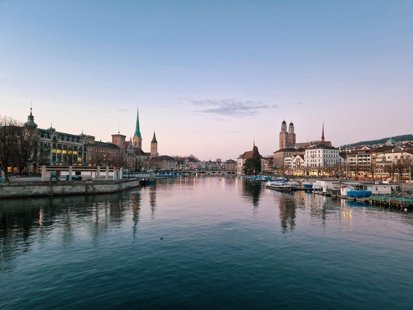 River running through a city with cathedral spires at dusk