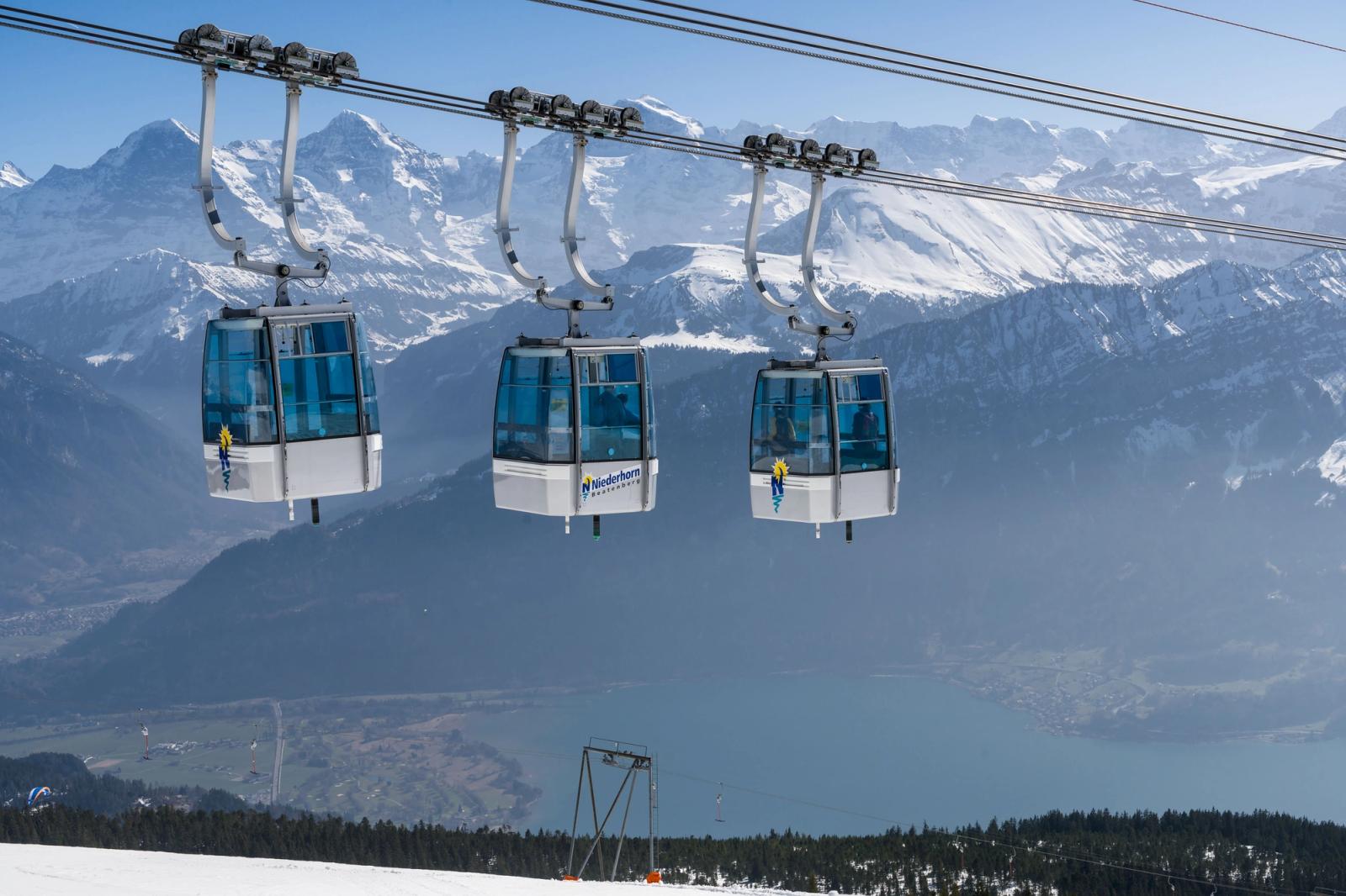 Cable cars overlooking the scenic Swiss Alps with clear blue skies