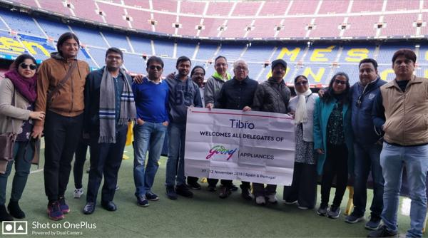 Group of people posing together on a soccer field.