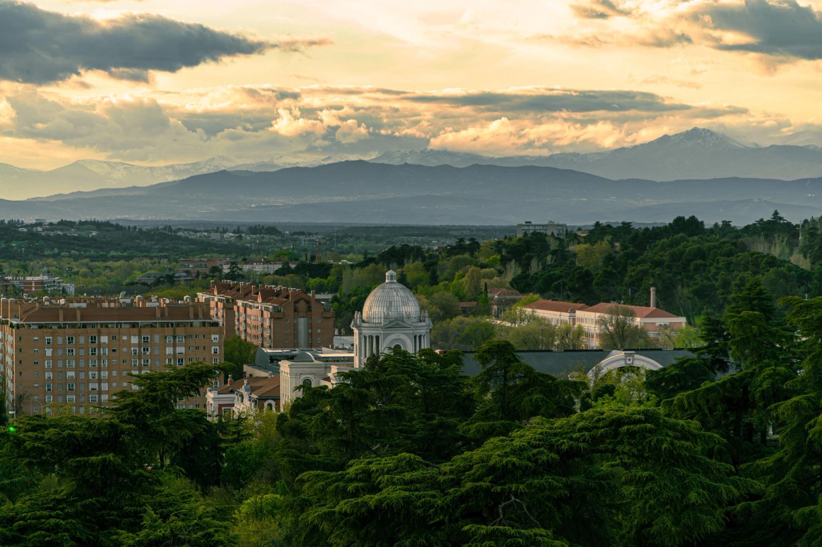 Lovely view of Madrid with lush greenery and Sierra mountains, captured at sunset