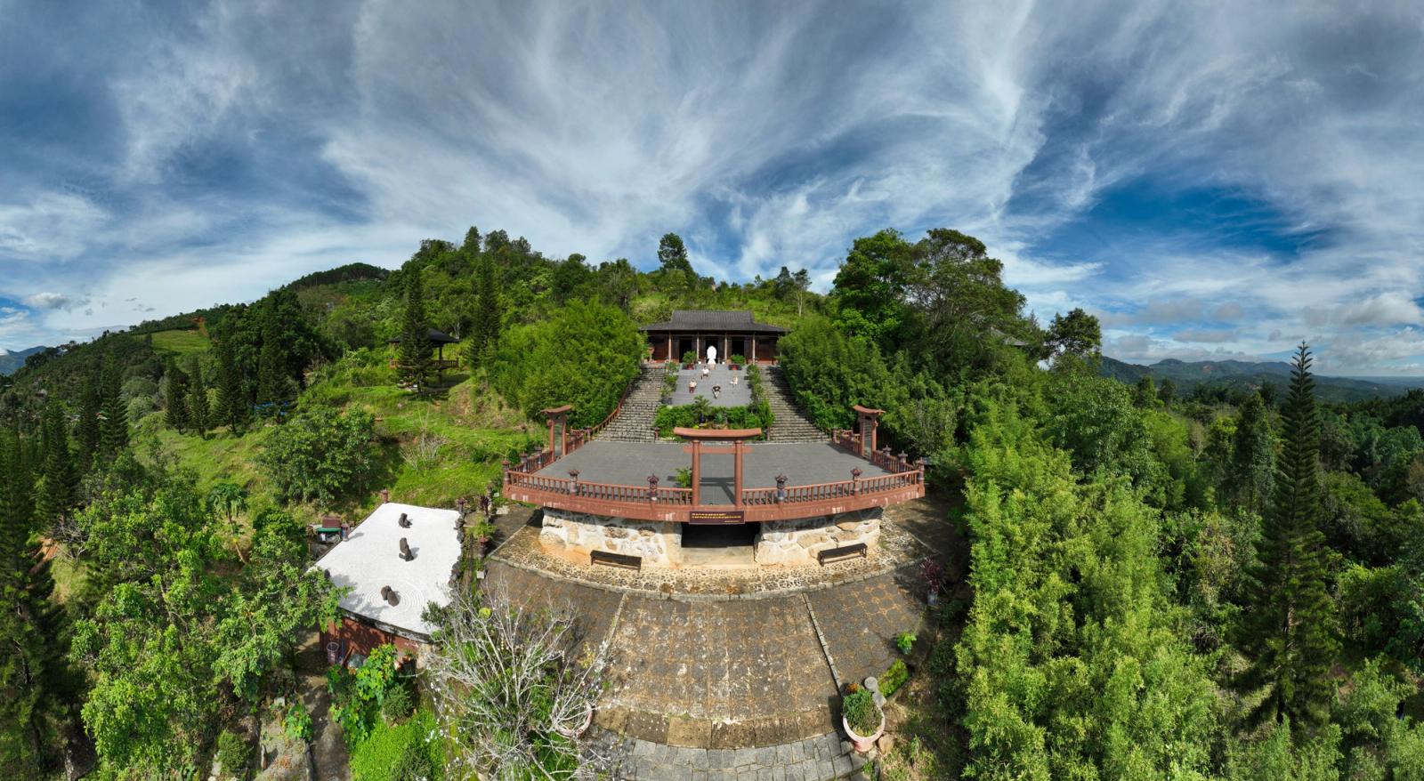 Aerial view of a Buddhist temple in lush green forest in Bảo Lâm, Vietnam