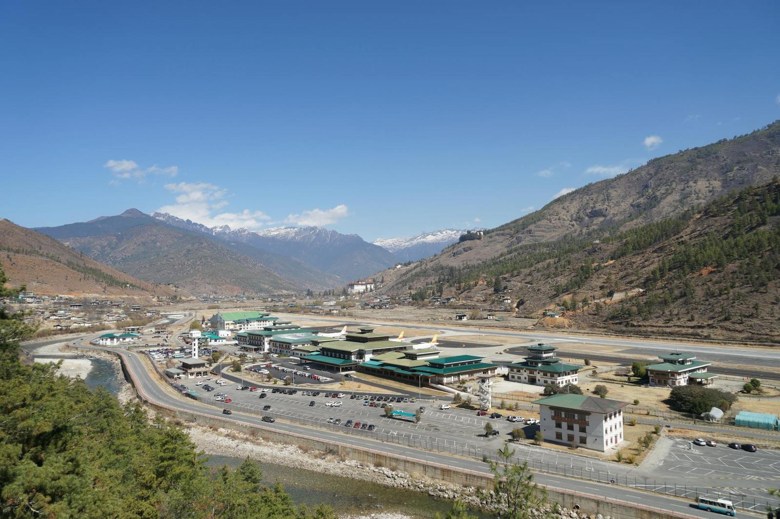 An airport runway and terminal buildings in a green mountain valley