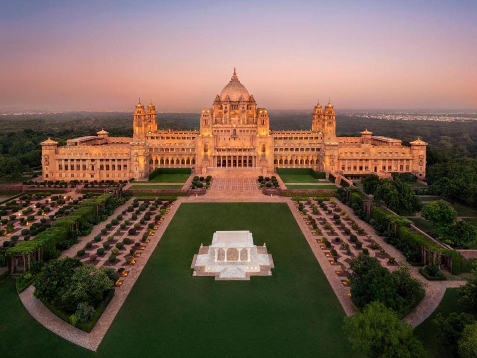 Aerial view of Umaid Bhawan Palace in Jodhpur at golden hour, sandstone facade and formal gardens