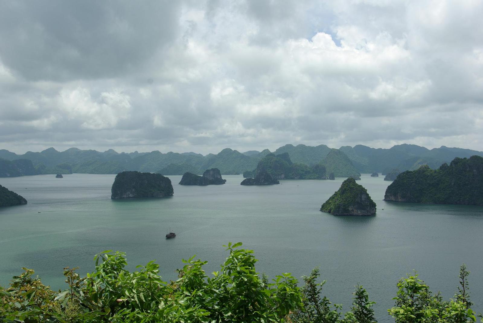 Aerial view of picturesque islands and tranquil waters in Halong Bay under a cloudy sky