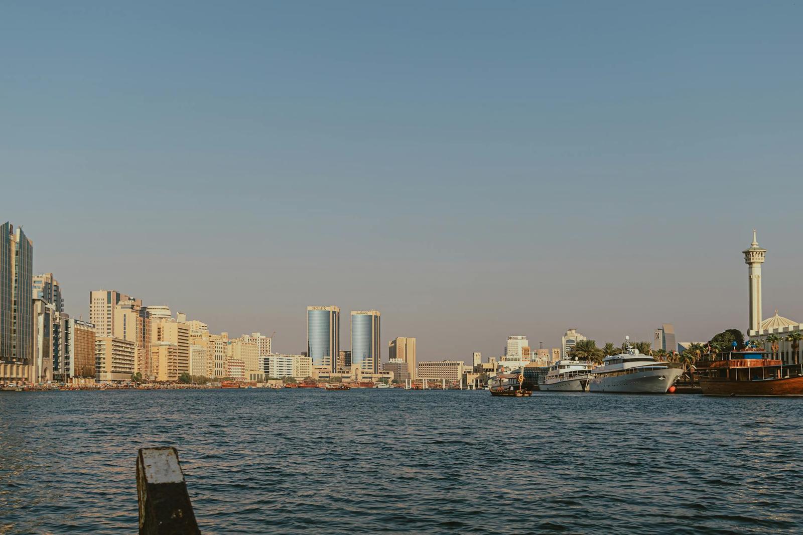 A waterfront skyline with yachts moored along a creek at golden hour