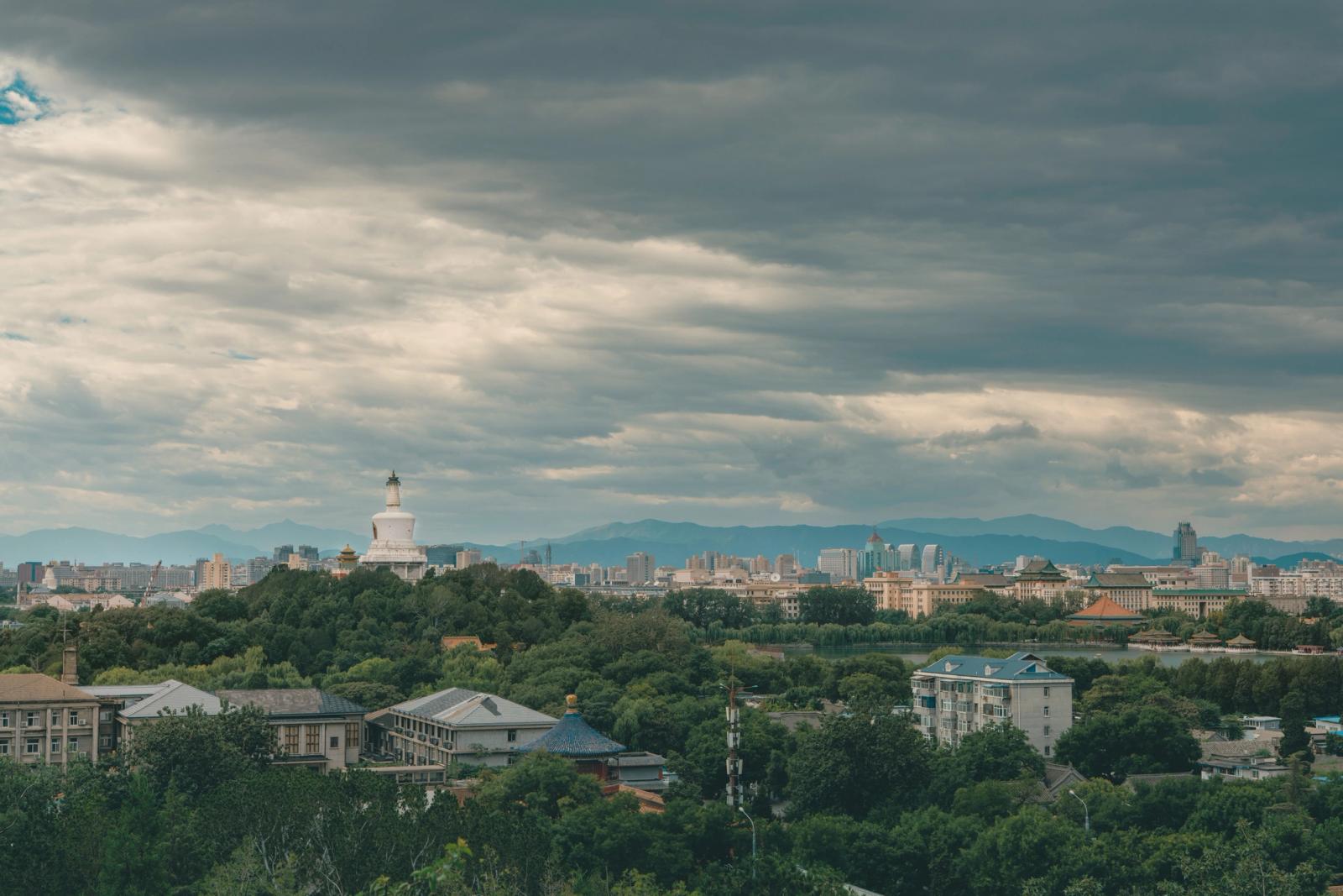 Panoramic view of Beijing with the iconic White Dagoba stupa under a cloudy sky
