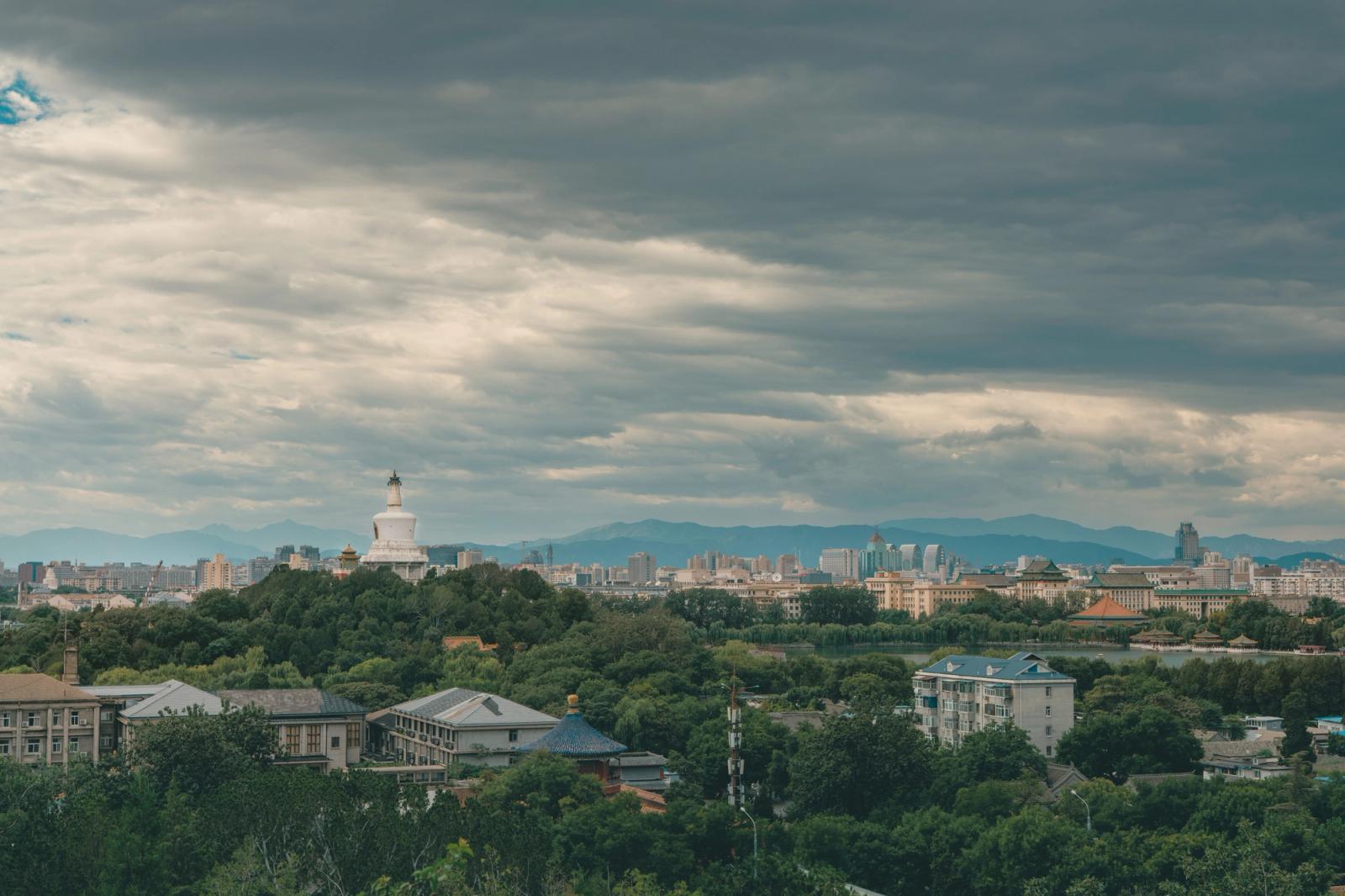 Panoramic view of Beijing with the iconic White Dagoba stupa under a cloudy sky