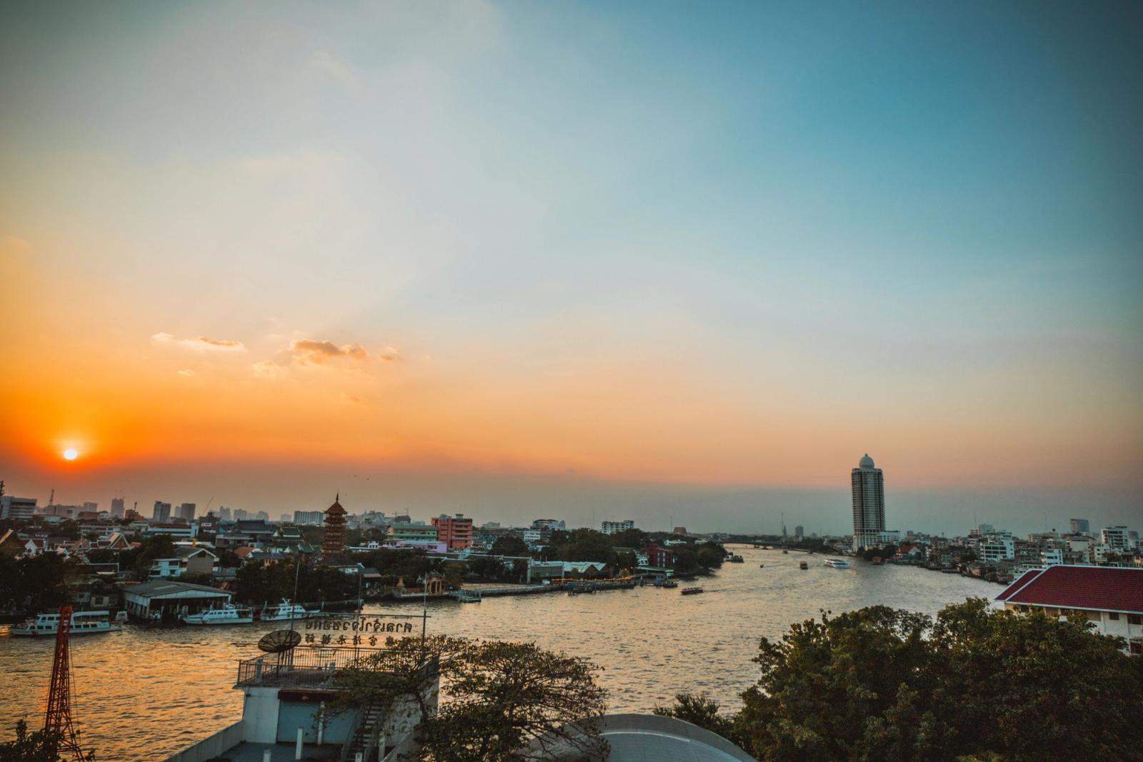 Stunning sunset view over Bangkok's Chao Phraya River with cityscape and skyline