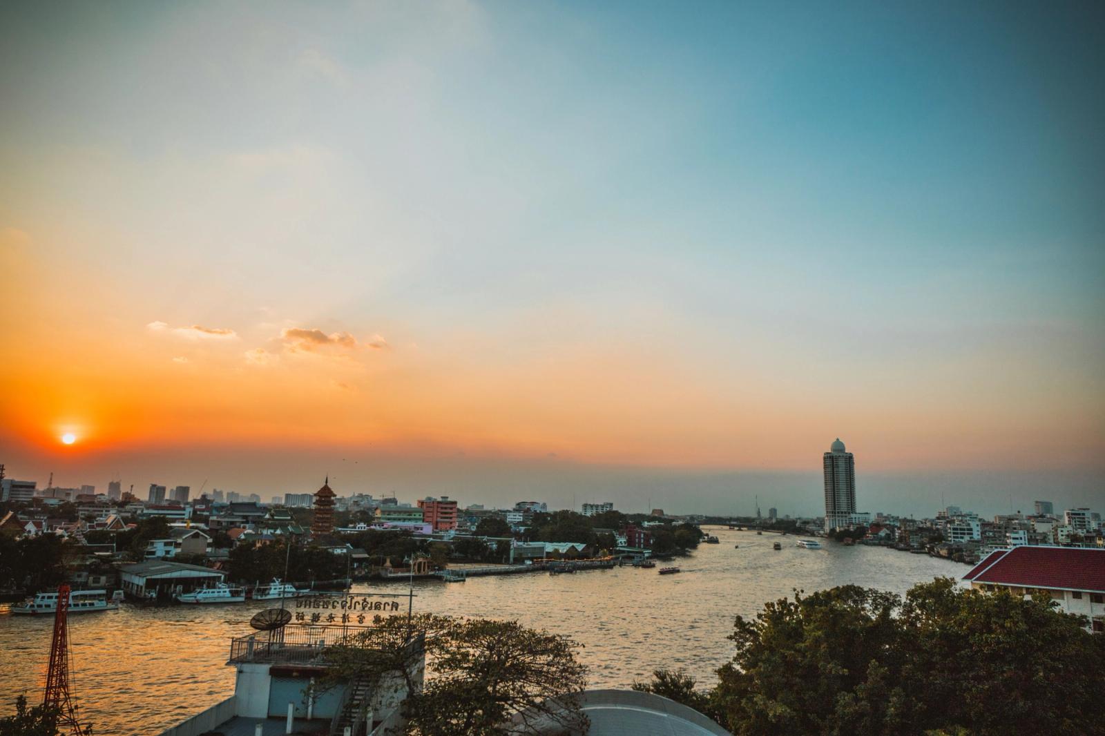 Stunning sunset view over Bangkok's Chao Phraya River with cityscape and skyline