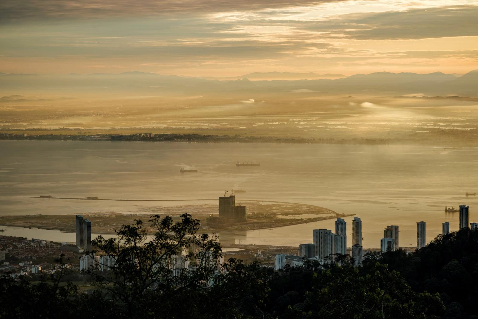 Stunning sunrise view over Penang from Bukit Bendera, Malaysia featuring skyscrapers and the coastline