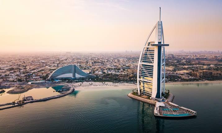 Burj Khalifa silhouetted above the Dubai skyline at sunset over water
