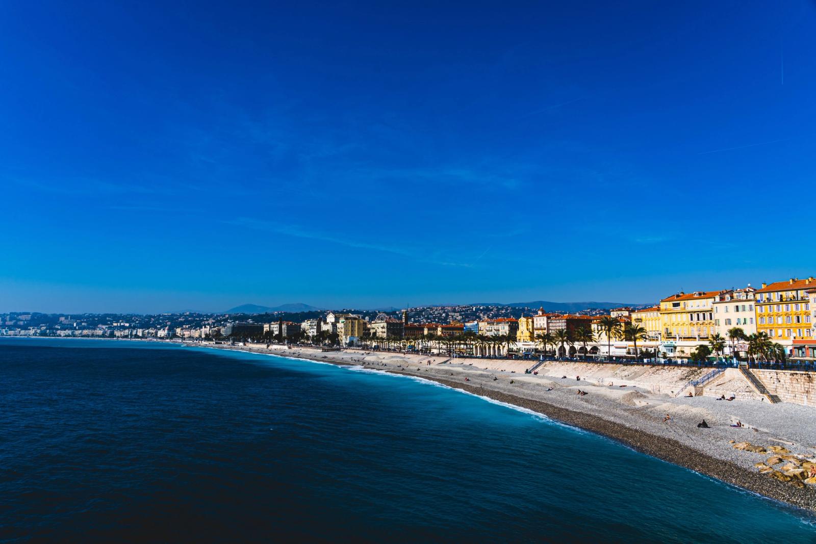 A vibrant beachfront view of Nice, France, capturing the azure waters and colorful architecture on a sunny day