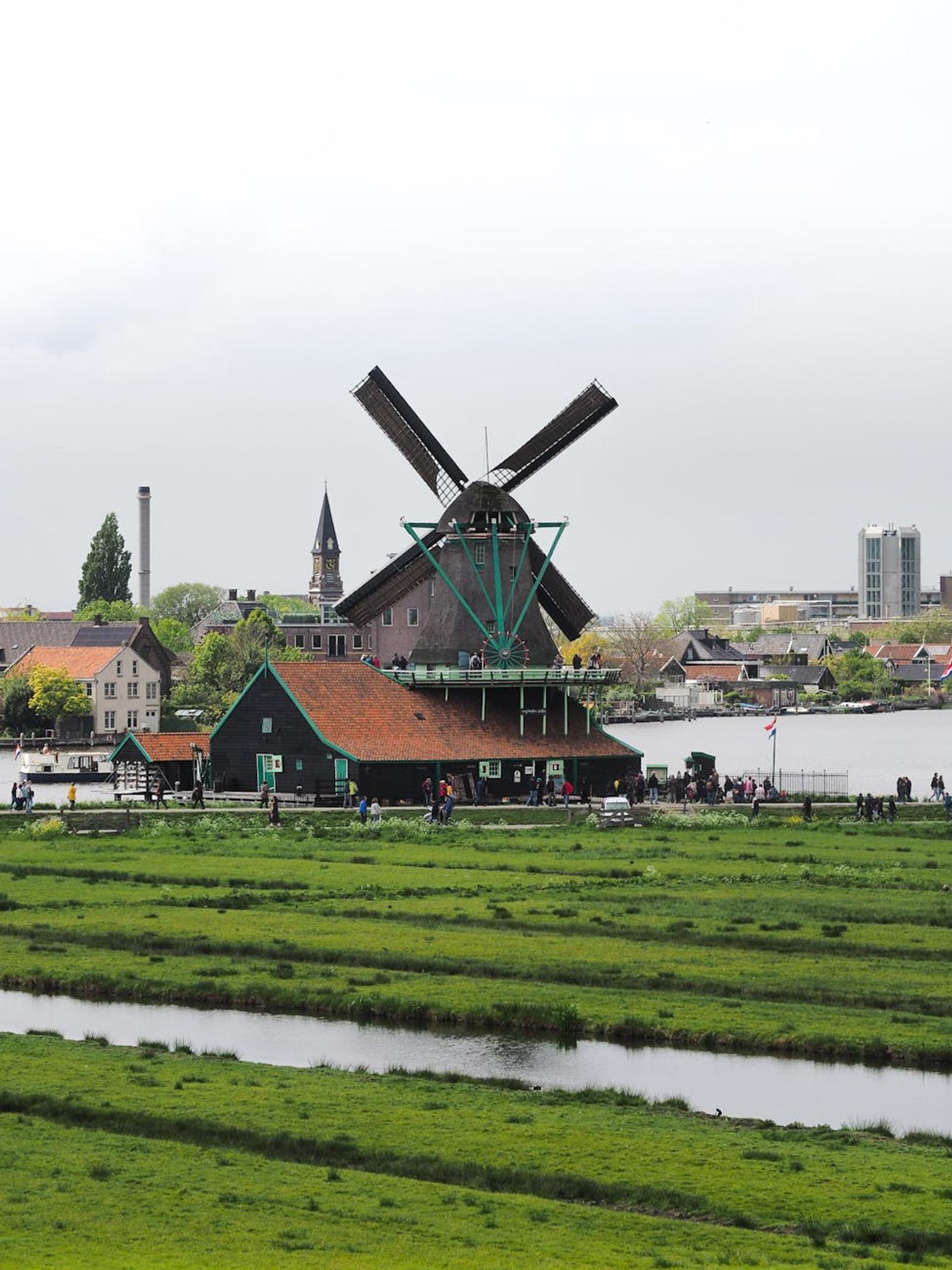 A picturesque scene of a classic Dutch windmill set against a rural backdrop in the Netherlands