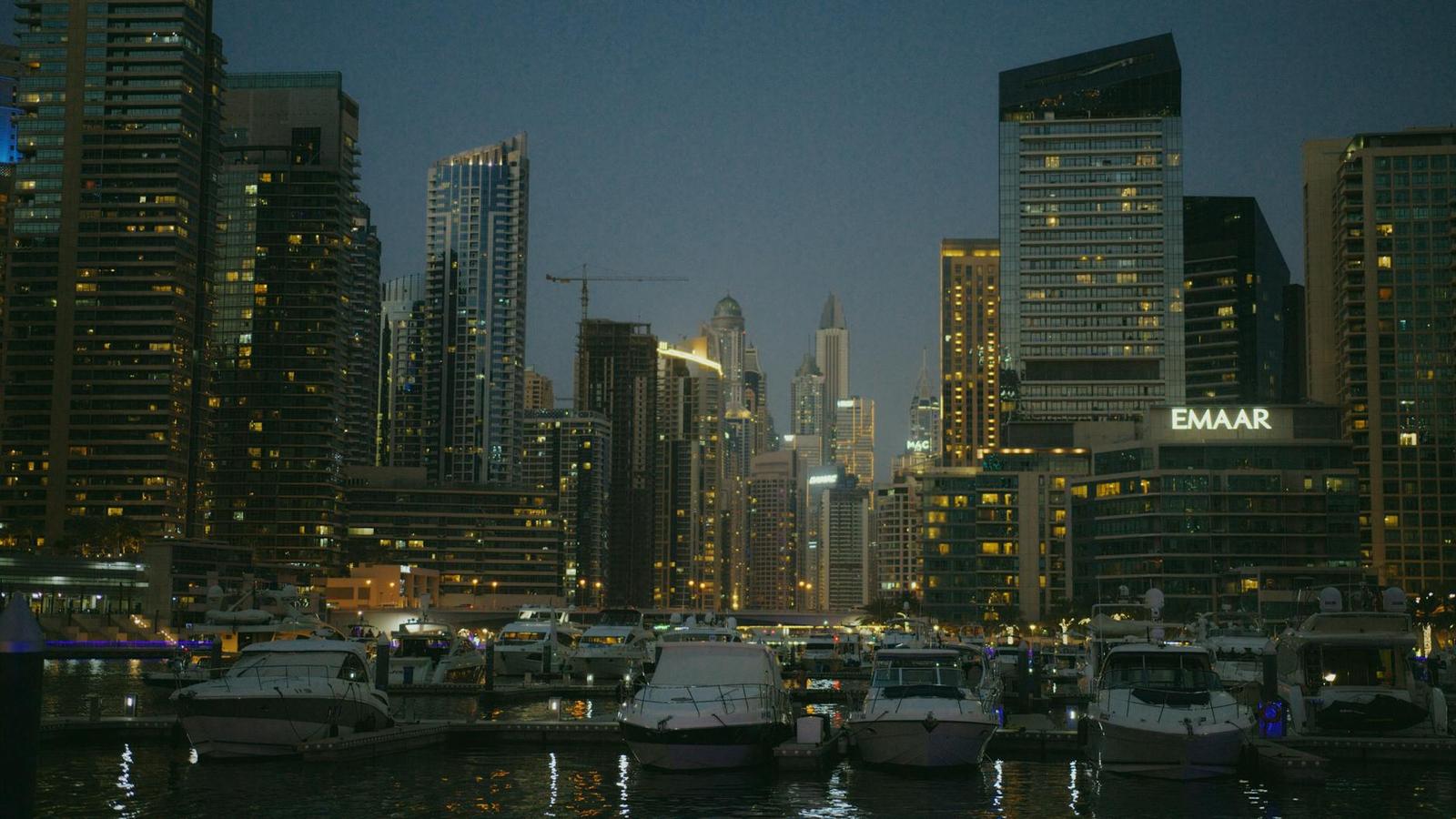 Dubai Marina at dusk with yachts lined along the promenade