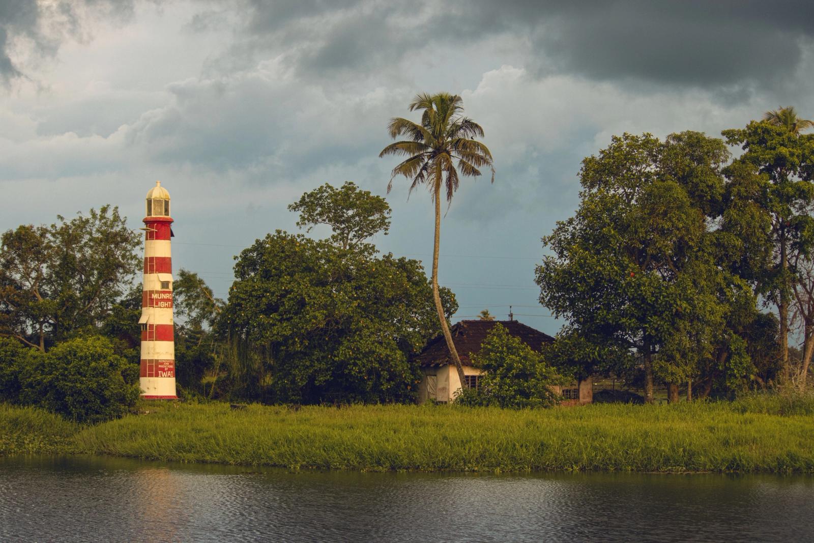 Scenic view of Munroe Lighthouse amidst greenery in Kottayam, India, under a moody sky