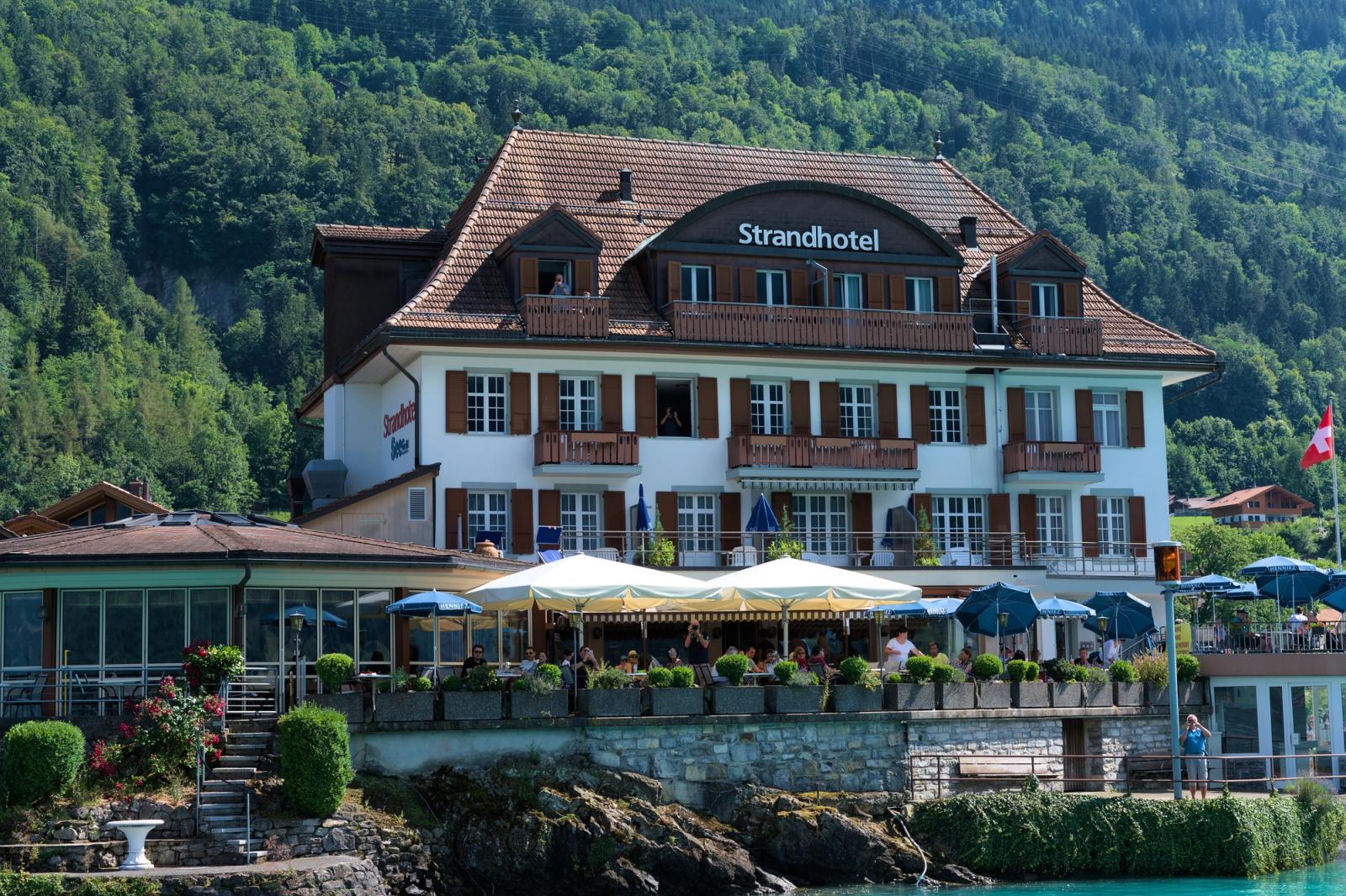 Idyllic view of Strandhotel against lush hills in Iseltwald, Switzerland