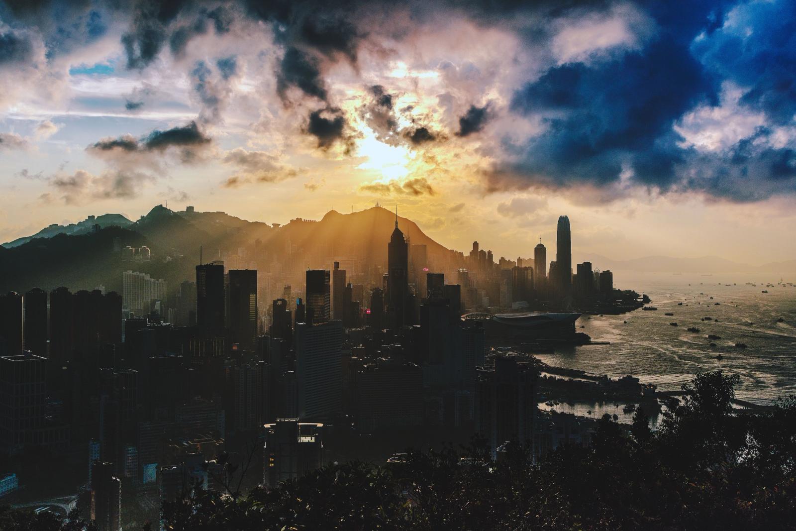 Dramatic sunset over the skyline of Hong Kong Island with vibrant colors and sea view