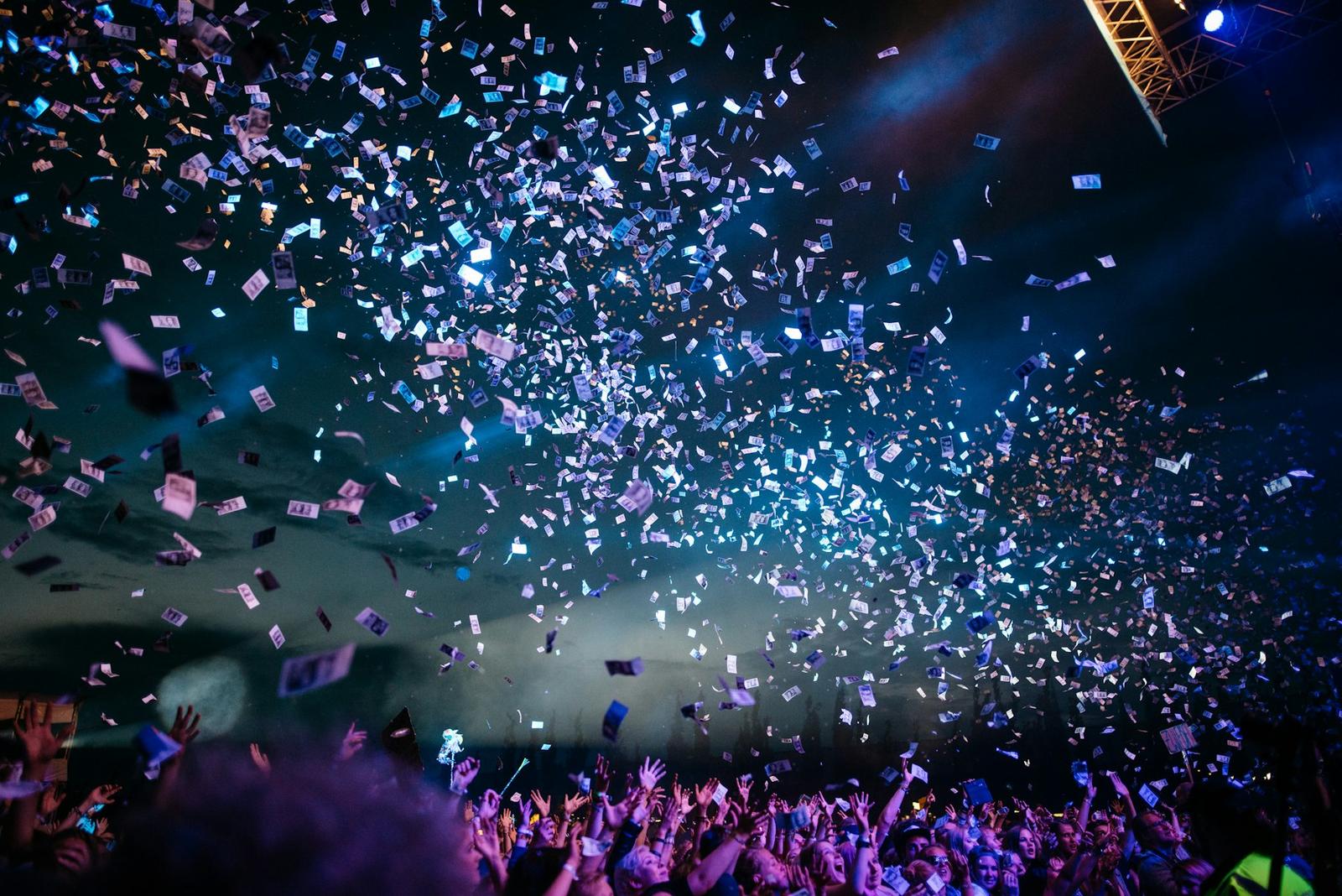 Stage lights over a crowd at an evening event