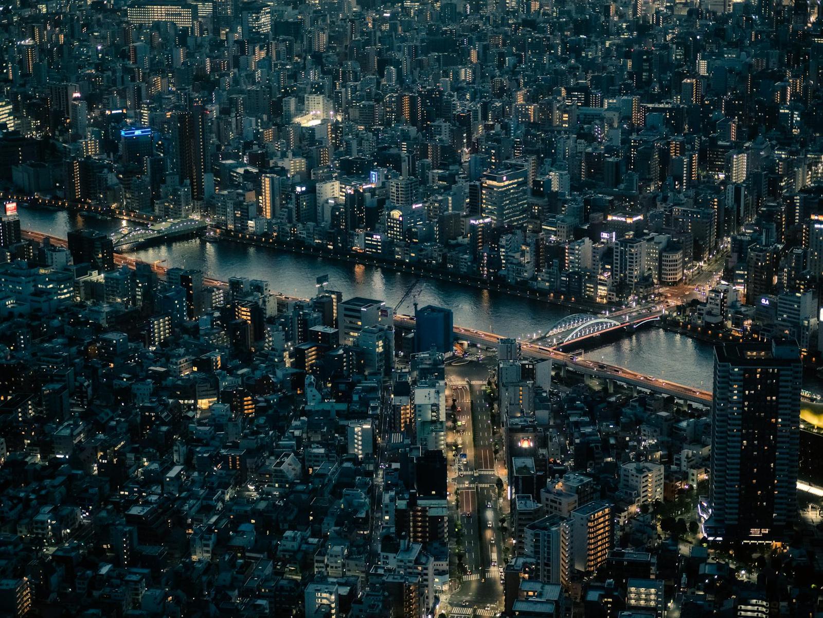 A dense city skyline lit up at night along a winding river