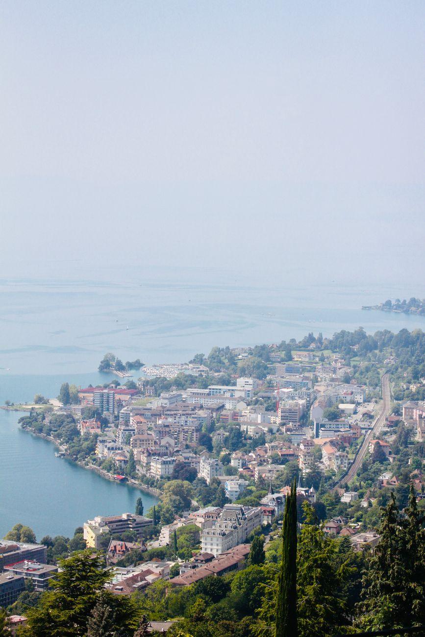 Hazy aerial view of a lakeside town nestled among green hills