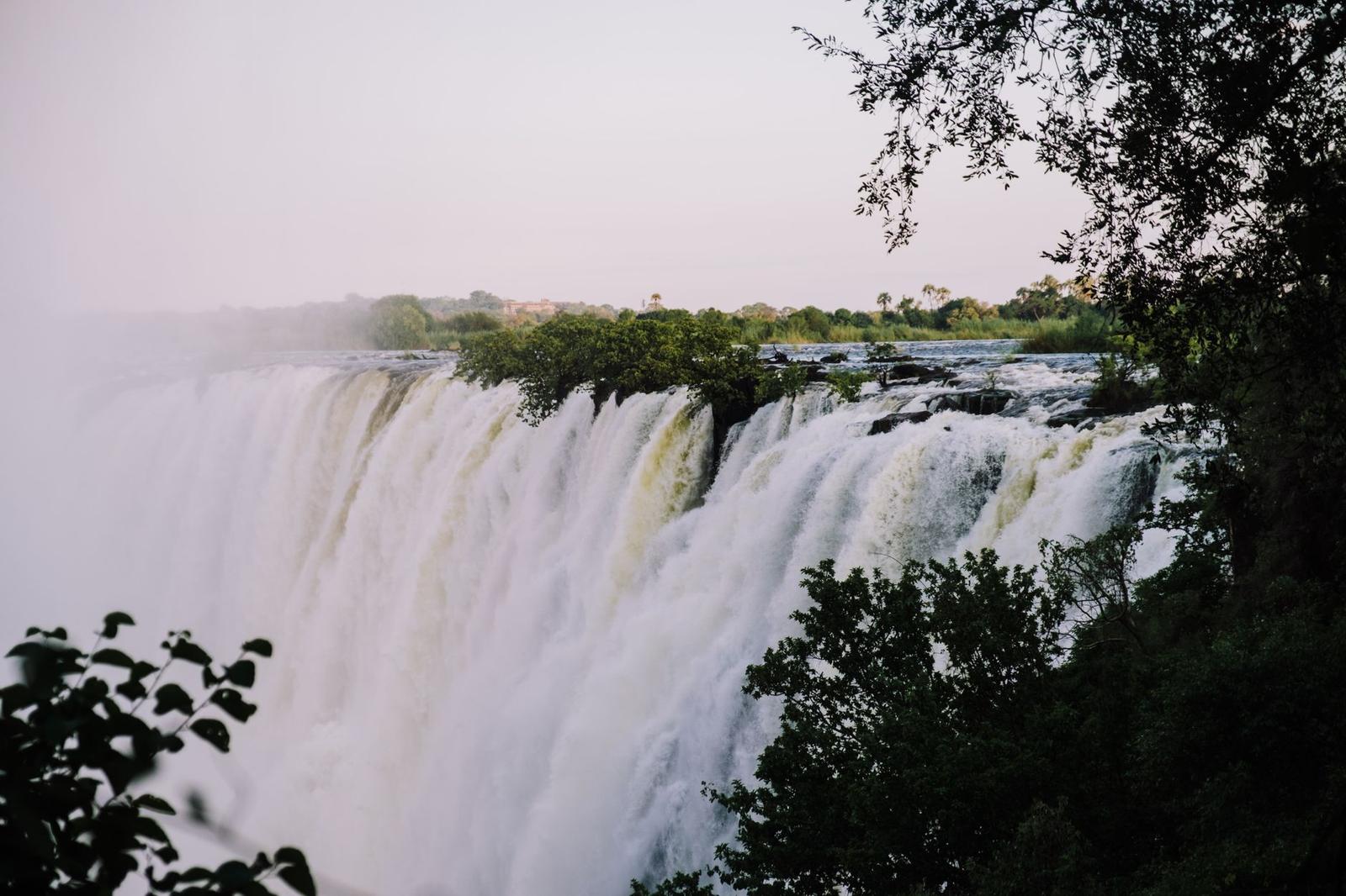 Breathtaking photo of Victoria Falls surrounded by lush greenery under a clear sky