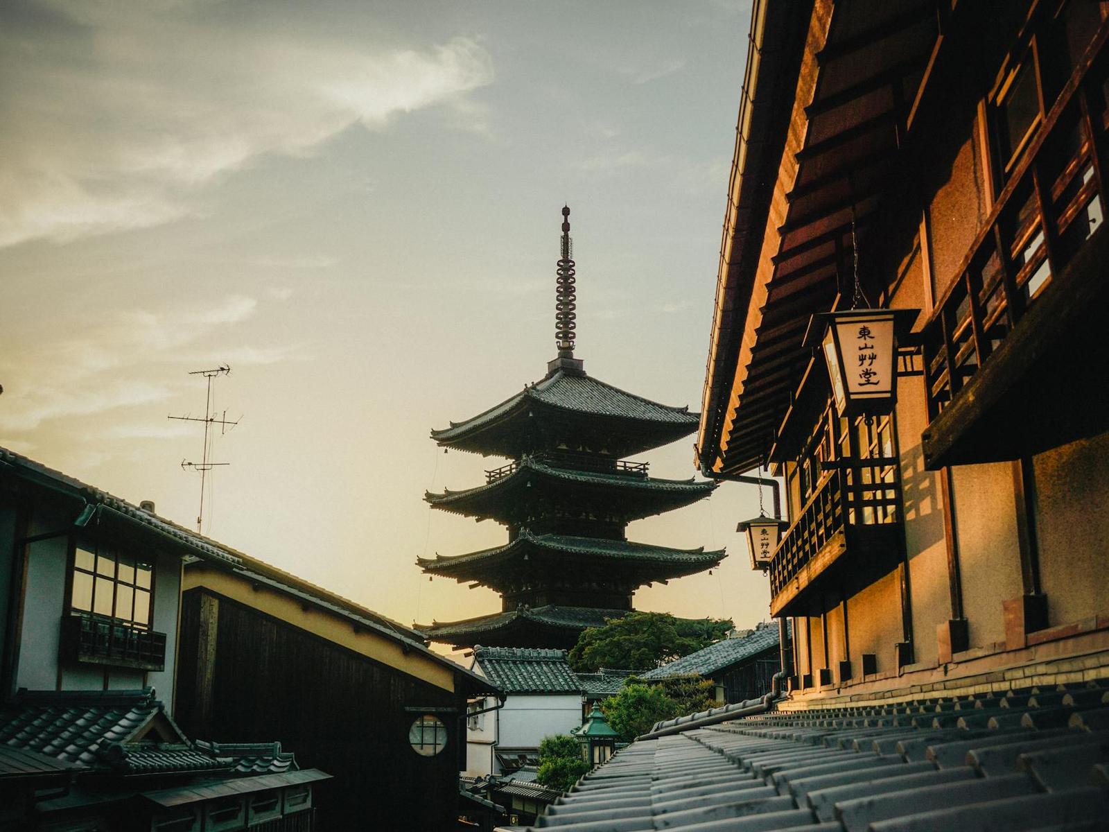 A five-story pagoda rising above traditional rooftops at golden hour