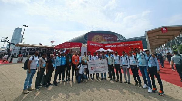 A group of people posing outside an exhibition venue