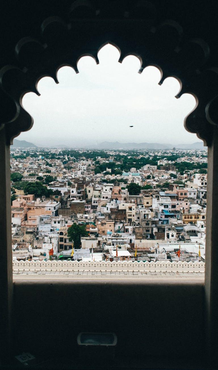 Scalloped stone archway framing a dense hillside cityscape below