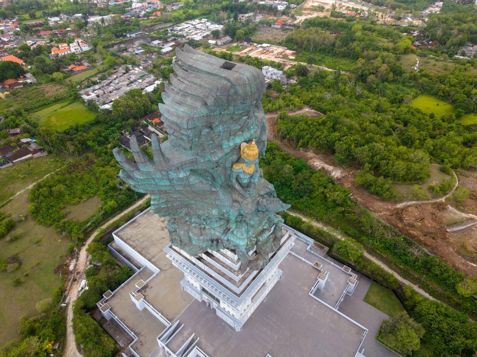 A striking aerial view of the Garuda Wisnu Kencana statue amidst lush greenery in Bali, Indonesia