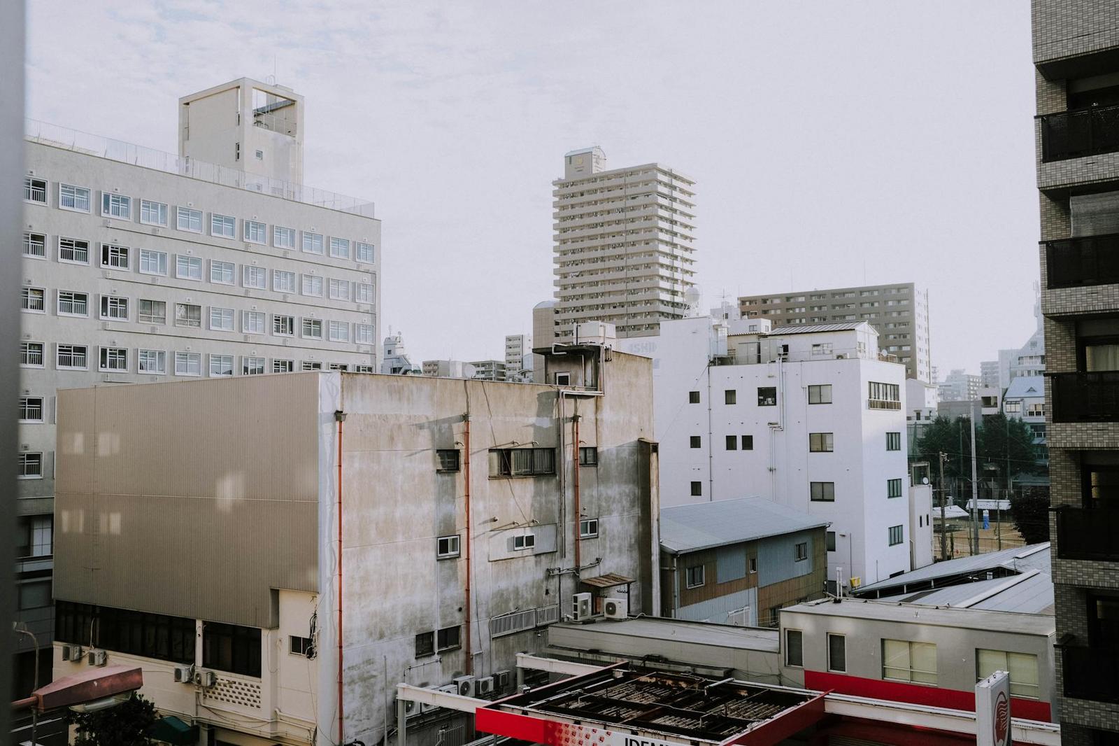 A view over mismatched apartment and office buildings under a grey sky