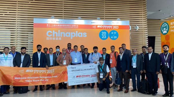 Group of people standing together in front of a large banner.