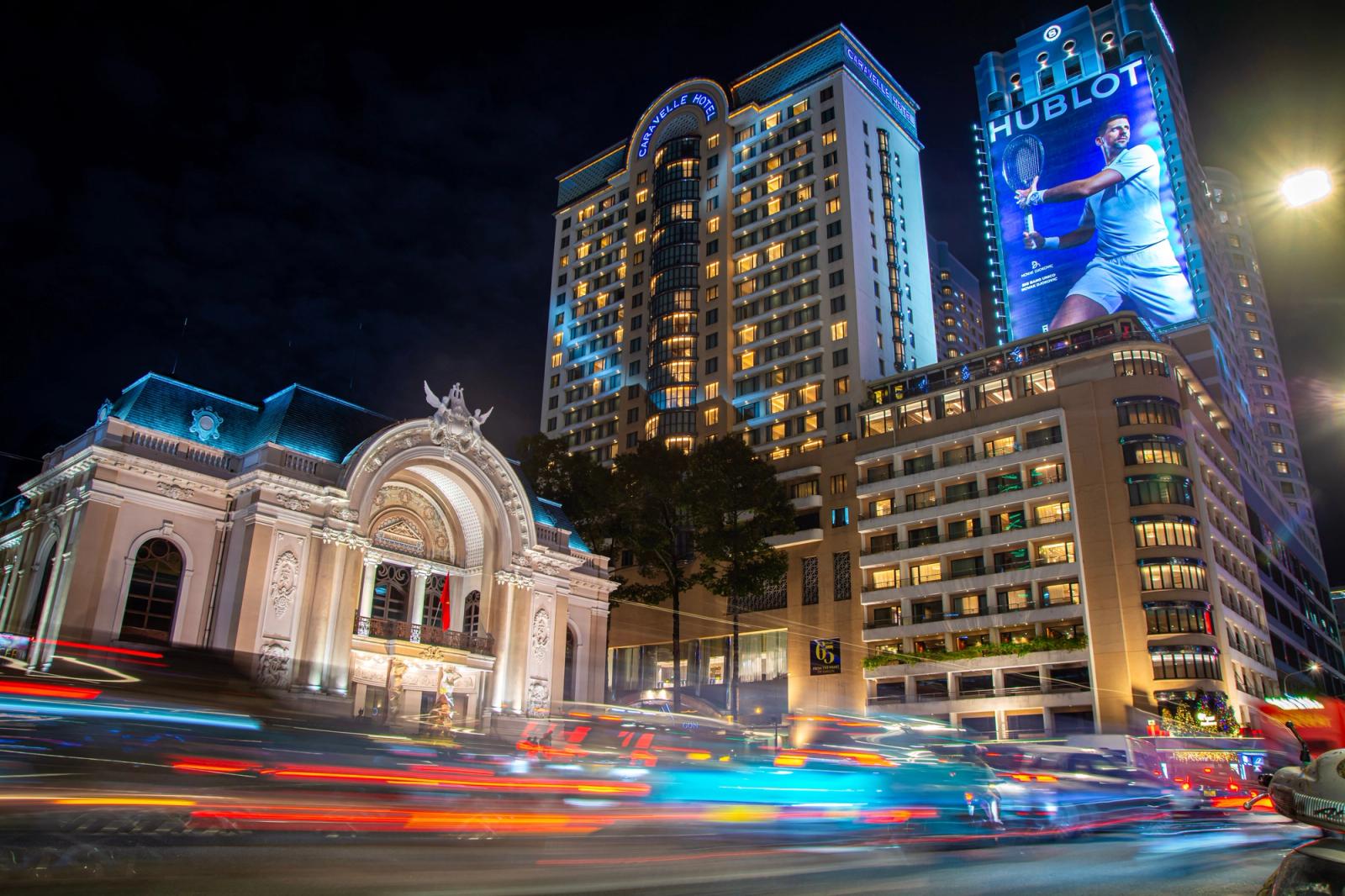 Dynamic night view in Ho Chi Minh City featuring the iconic Opera House and bustling city lights